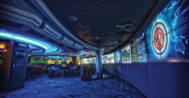 A cybersecurity analyst monitors multiple screens showing network data and security alerts.