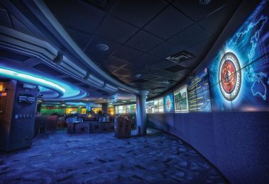 A cybersecurity analyst monitors multiple screens showing network data and security alerts.