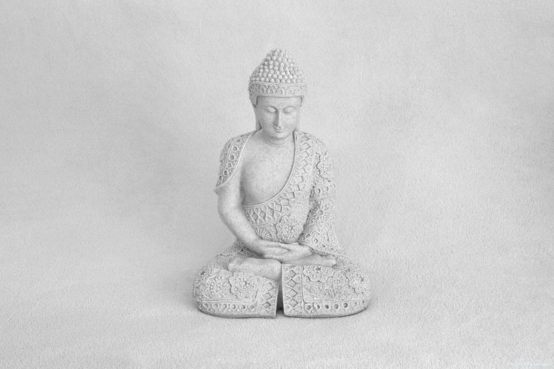 A person meditating outdoors with calm, slow breathing in a peaceful natural setting.